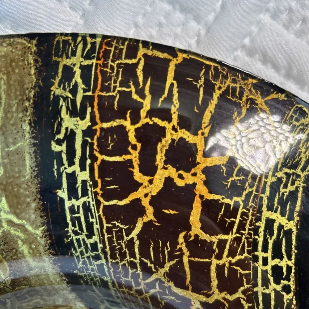 Glass bowl features an asymmetrical shape with a striking black and gold crackle